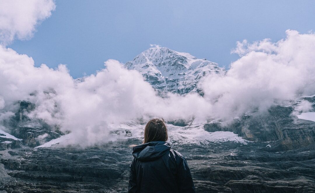 person climbing mountain peak