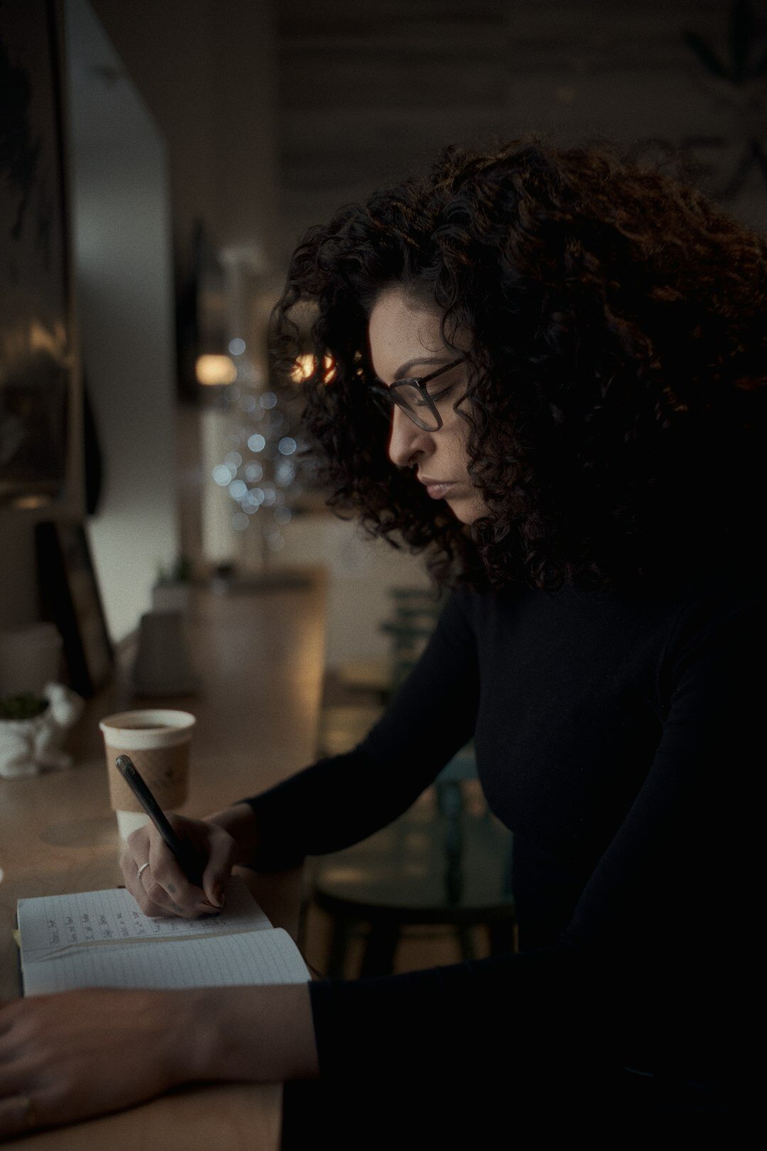 Brazilian woman writing in a notebook at a bright desk